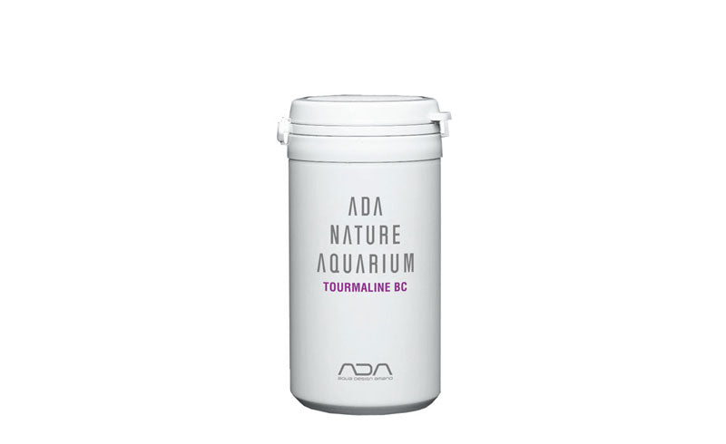 Das Bild zeigt eine weiße Kunststoffdose mit einem weißen Deckel. Auf der Dose steht in schwarzer Schrift "ADA NATURE AQUARIUM" und darunter in größerer Schrift "TOURMALINE BC". Es ist das Logo von ADA in violetter Farbe sichtbar.
