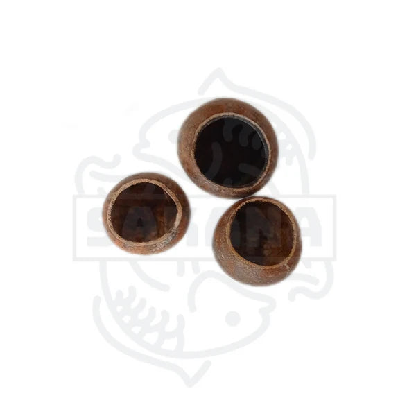 Das Bild zeigt drei kleine, hohle, braune Objekte, die vermutlich aus der Schale einer Frucht oder Nuss bestehen. Sie haben eine runde Form und eine glatte, leicht glänzende Oberfläche.